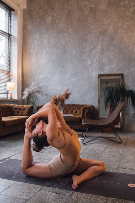 Woman peacefully doing a yoga pose on a mat in her living room